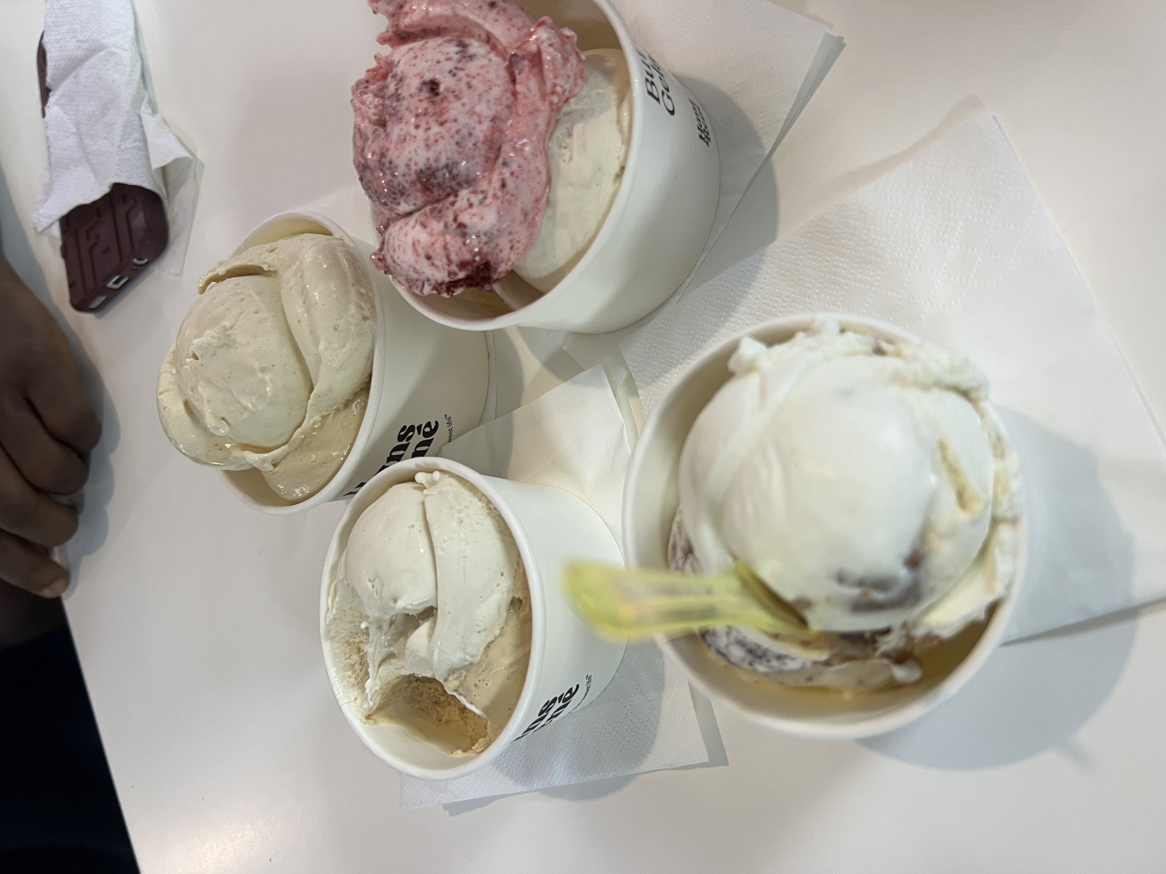 Photo shows four (4) separate cups containing two (2) scoops of gelato. Each cup is placed on a white serviette.